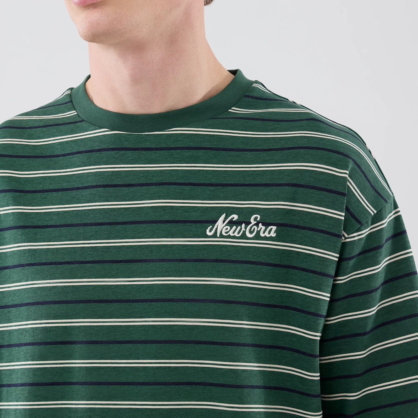 The model is wearing this New Era Stripe Oversized T-Shirt in dark green. 5