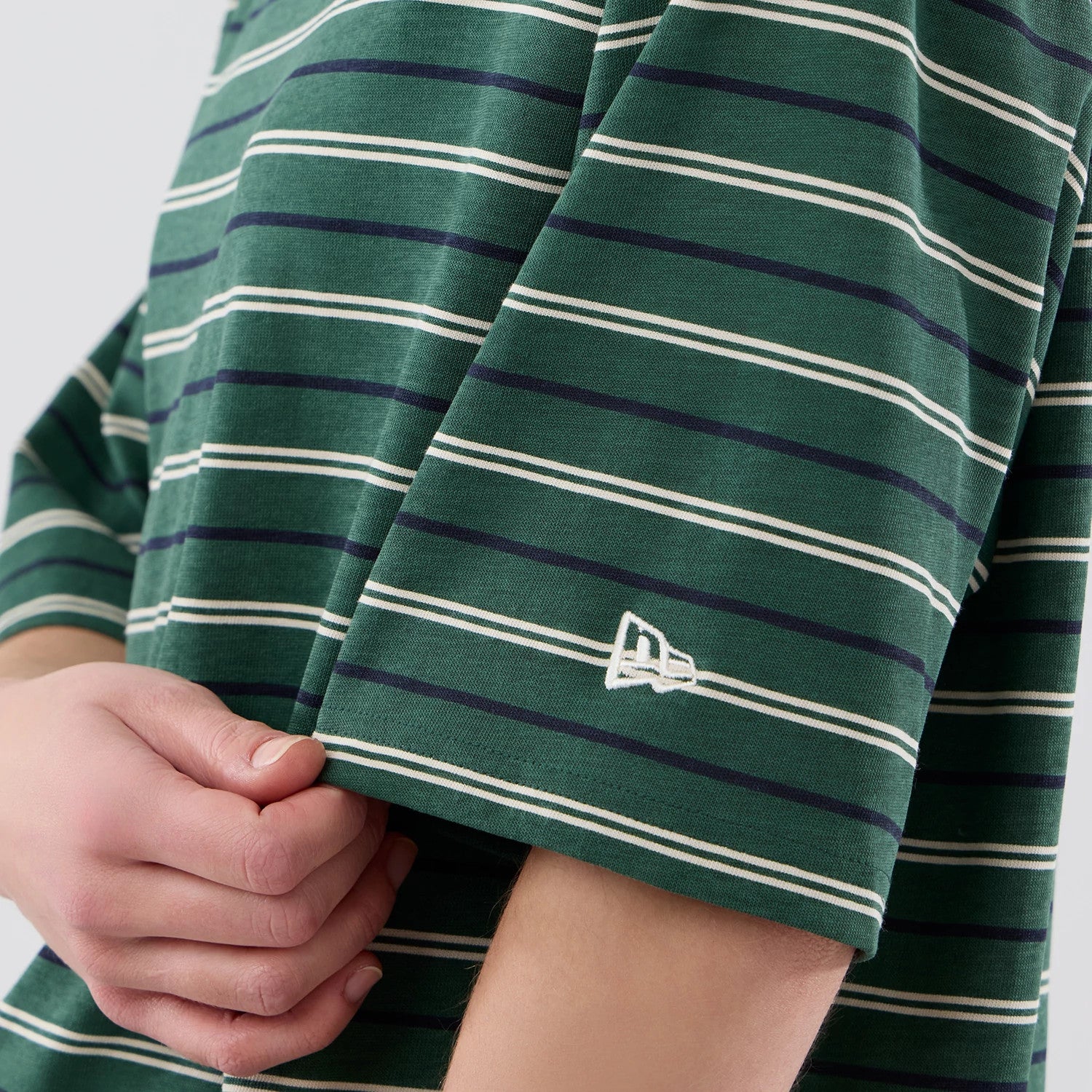 The model is wearing this New Era Stripe Oversized T-Shirt in dark green. 7