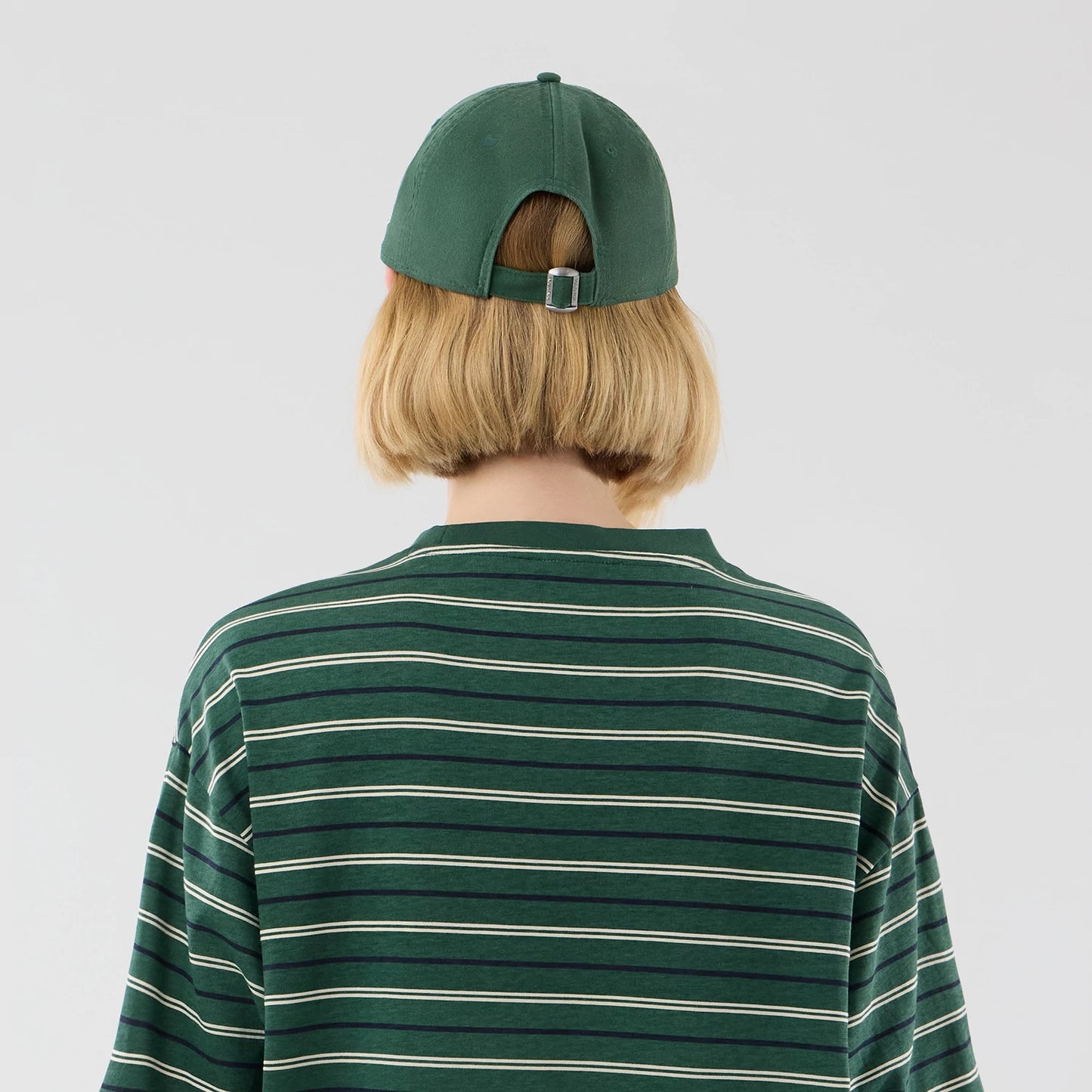 The model is wearing this New Era Stripe Oversized T-Shirt in dark green. 8