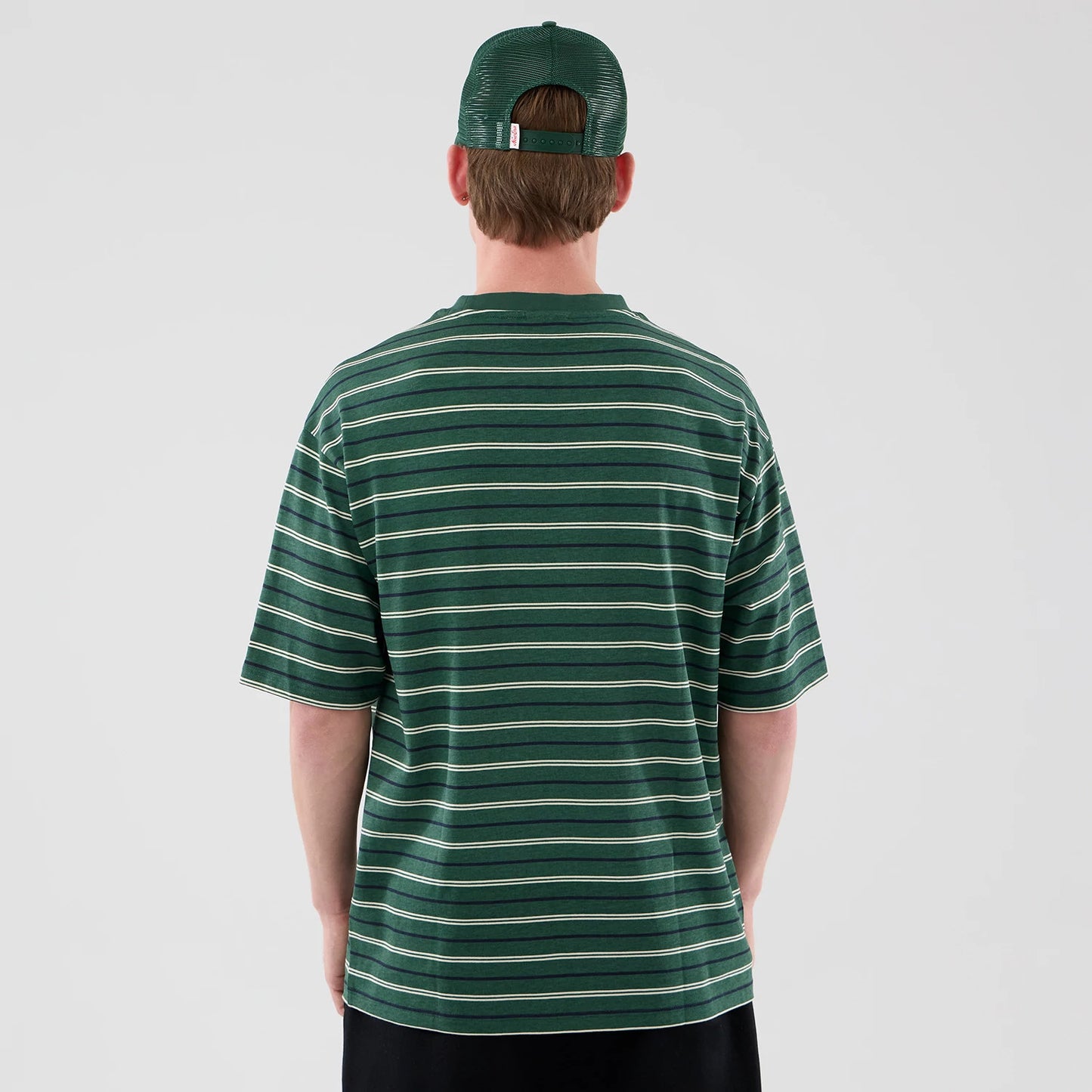 The model is wearing this New Era Stripe Oversized T-Shirt in dark green. 2