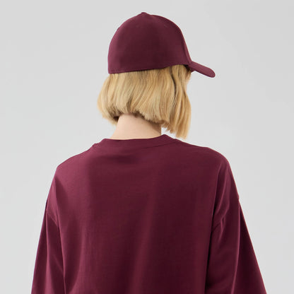 The model is wearing this MLB Midi League Essential Athletics Oversized T-Shirt in dark red. 8
