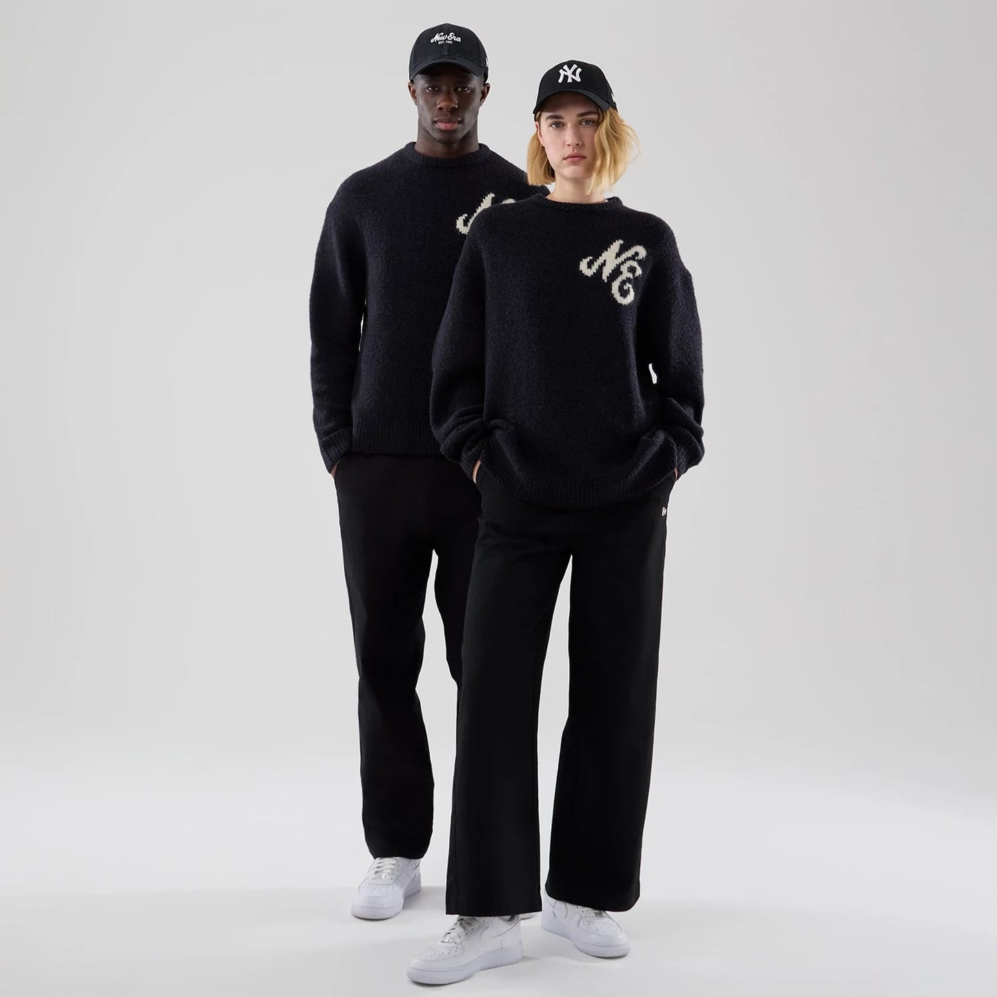 The model is wearing this New Era Knit Heritage Knitted Sweater in navy. 1