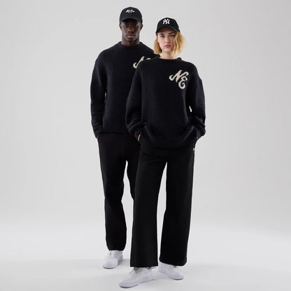 The model is wearing this New Era Knit Heritage Knitted Sweater in navy. 1