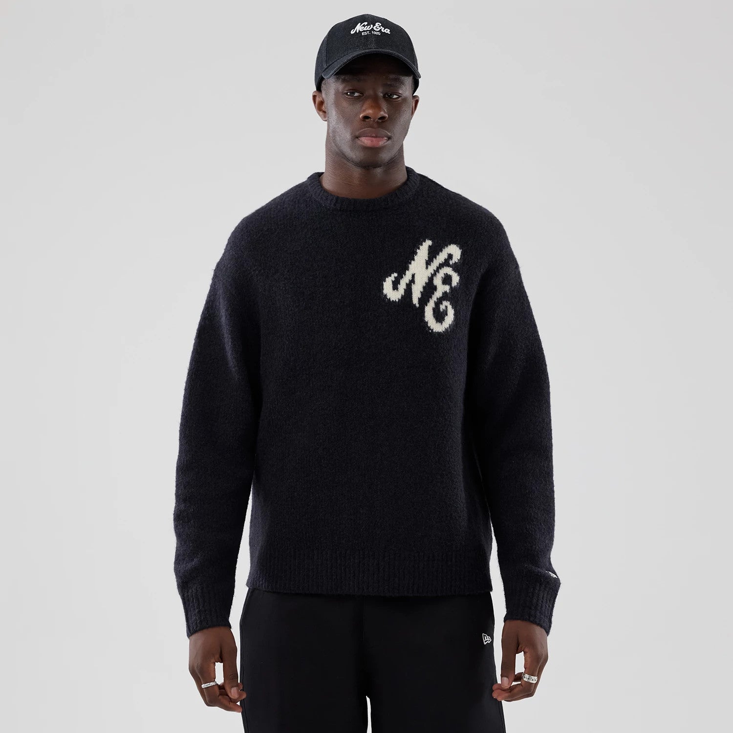 The model is wearing this New Era Knit Heritage Knitted Sweater in navy. 3