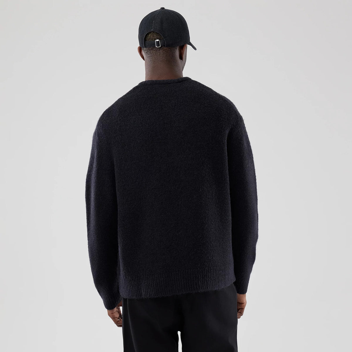 The model is wearing this New Era Knit Heritage Knitted Sweater in navy. 2