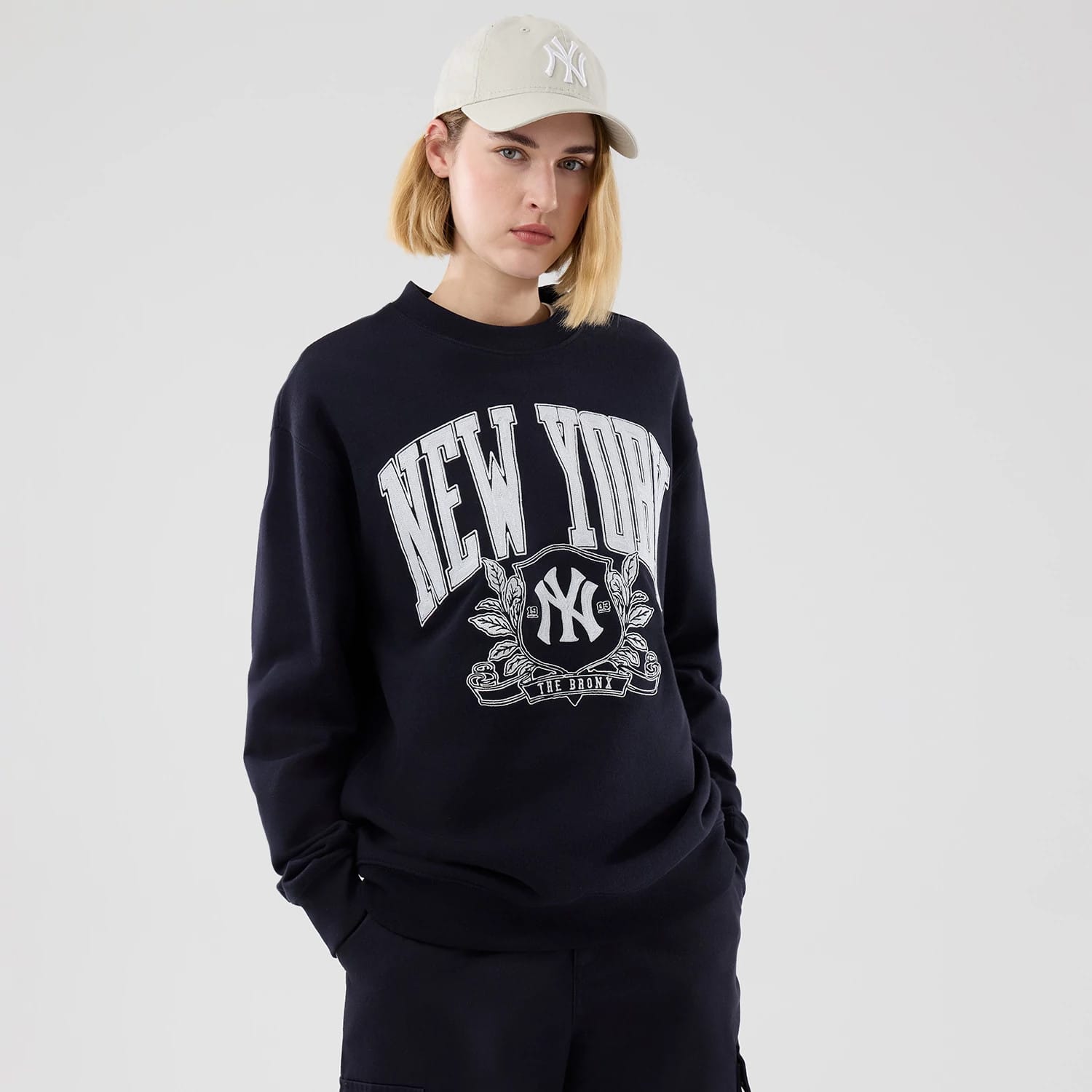 The model is wearing this MLB Arch Graphic New York Yankees Oversized Crew Neck Sweater in navy. 4