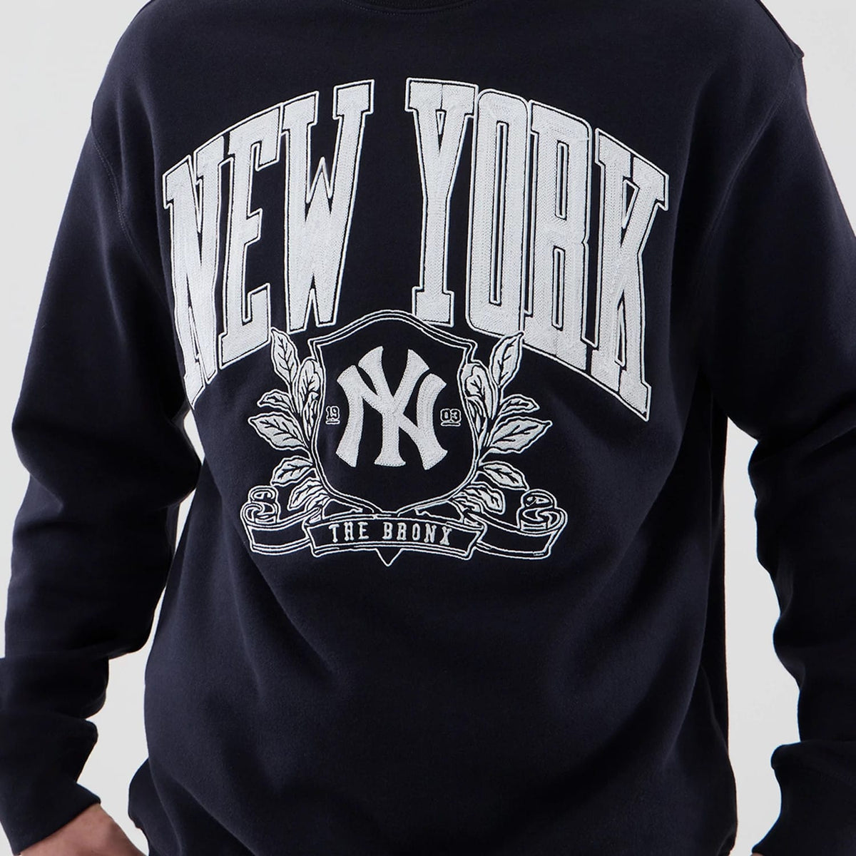 The model is wearing this MLB Arch Graphic New York Yankees Oversized Crew Neck Sweater in navy. 5