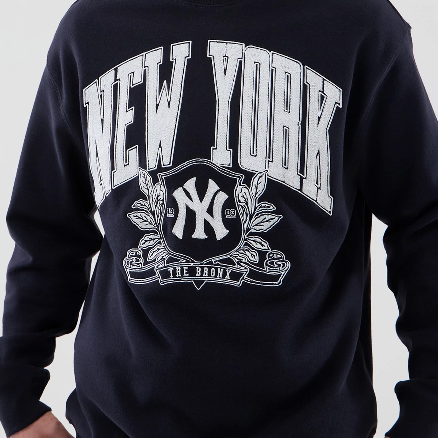The model is wearing this MLB Arch Graphic New York Yankees Oversized Crew Neck Sweater in navy. 5