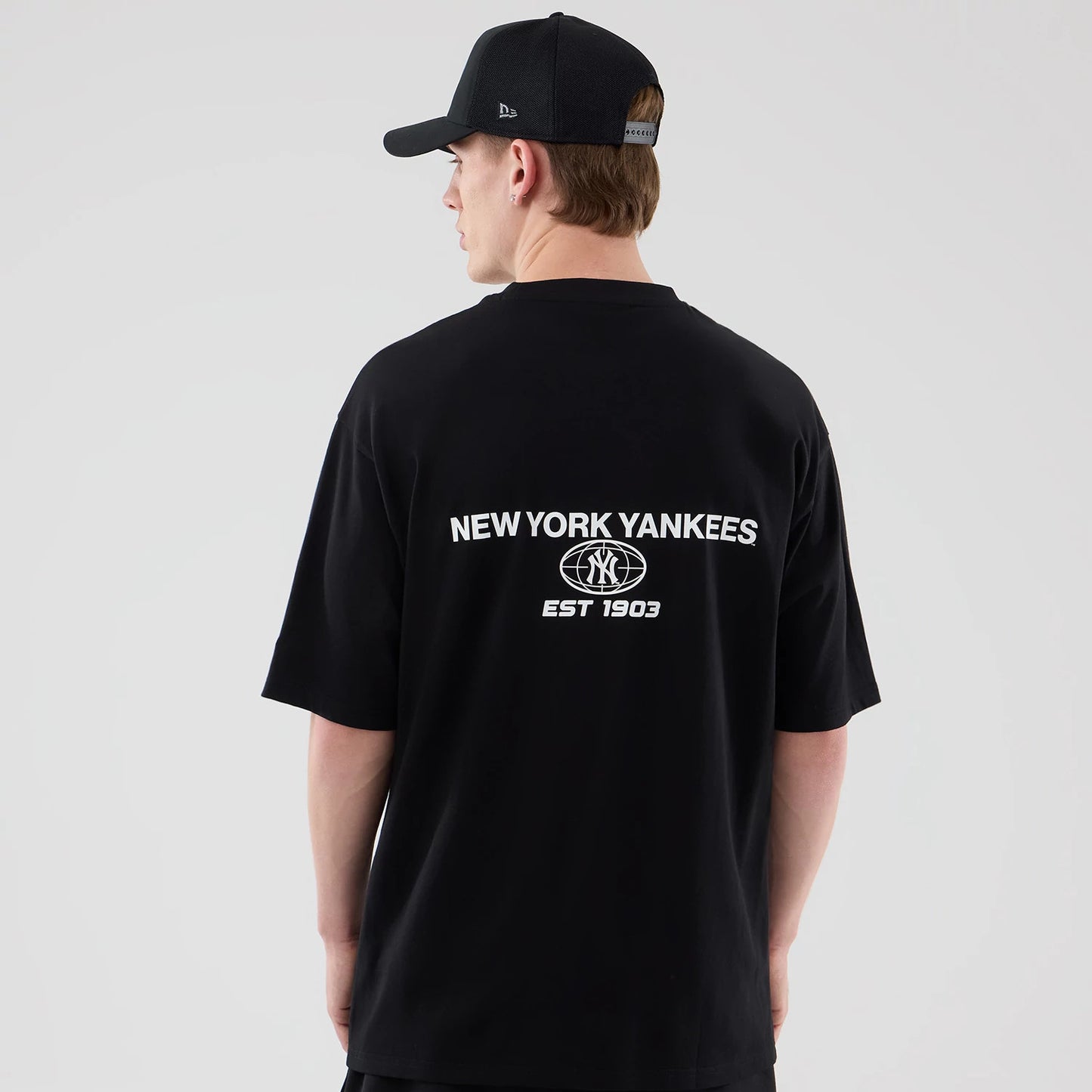 The model is wearing this MLB Logo Graphic New York Yankees Oversized T-Shirt in black. 2