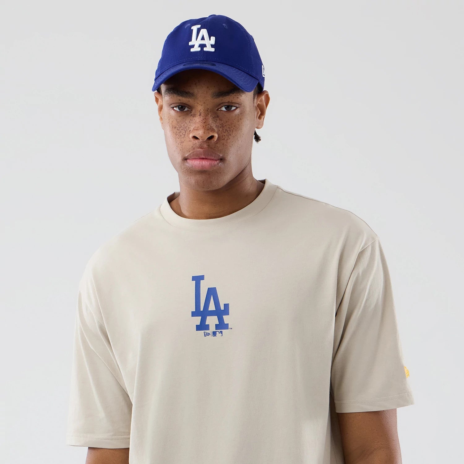 The model is wearing this MLB Food Graphic LA Dodgers Oversized T-Shirt in cream. 3