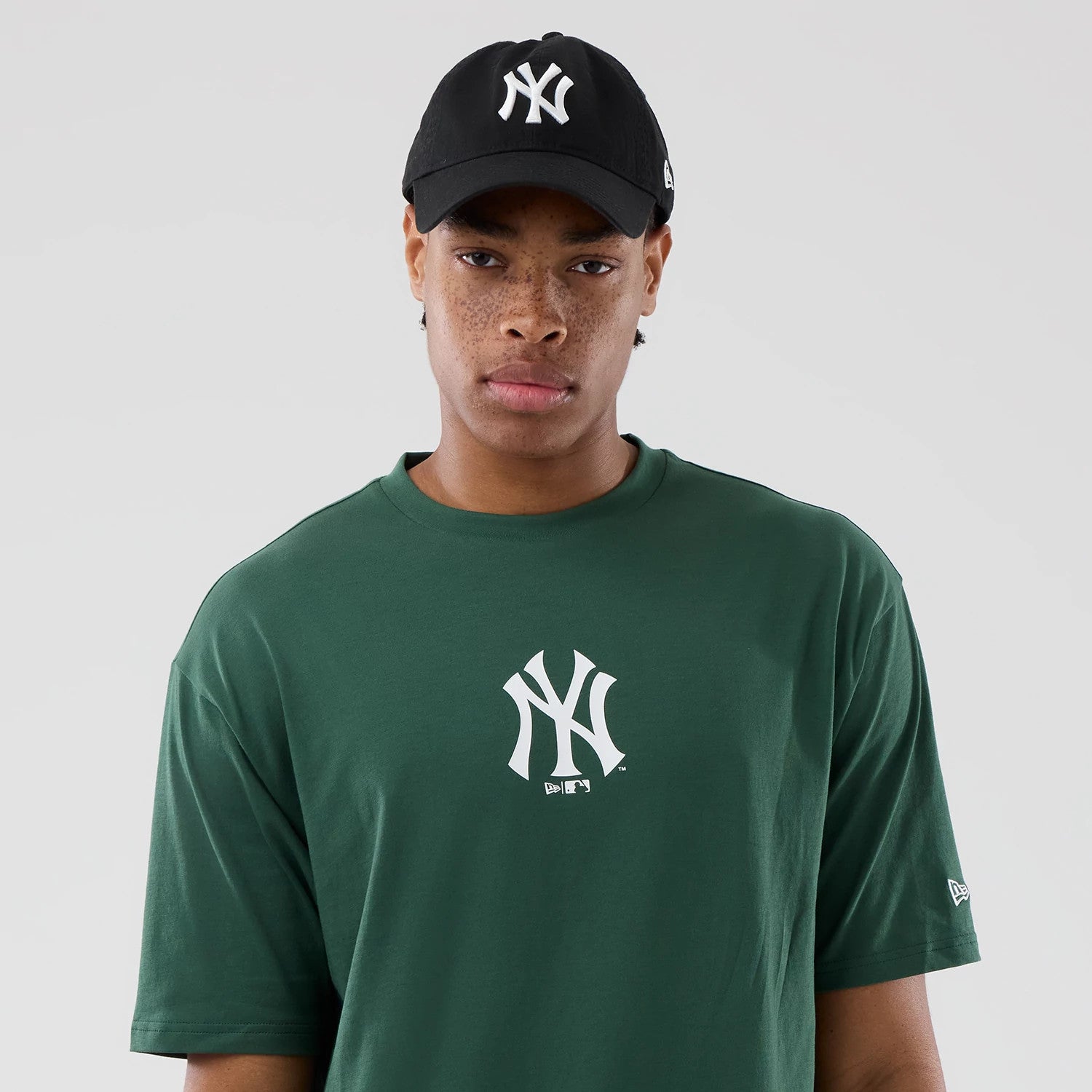 The model is wearing this MLB Food Graphic New York Yankees Oversized T-Shirt in dark green. 6