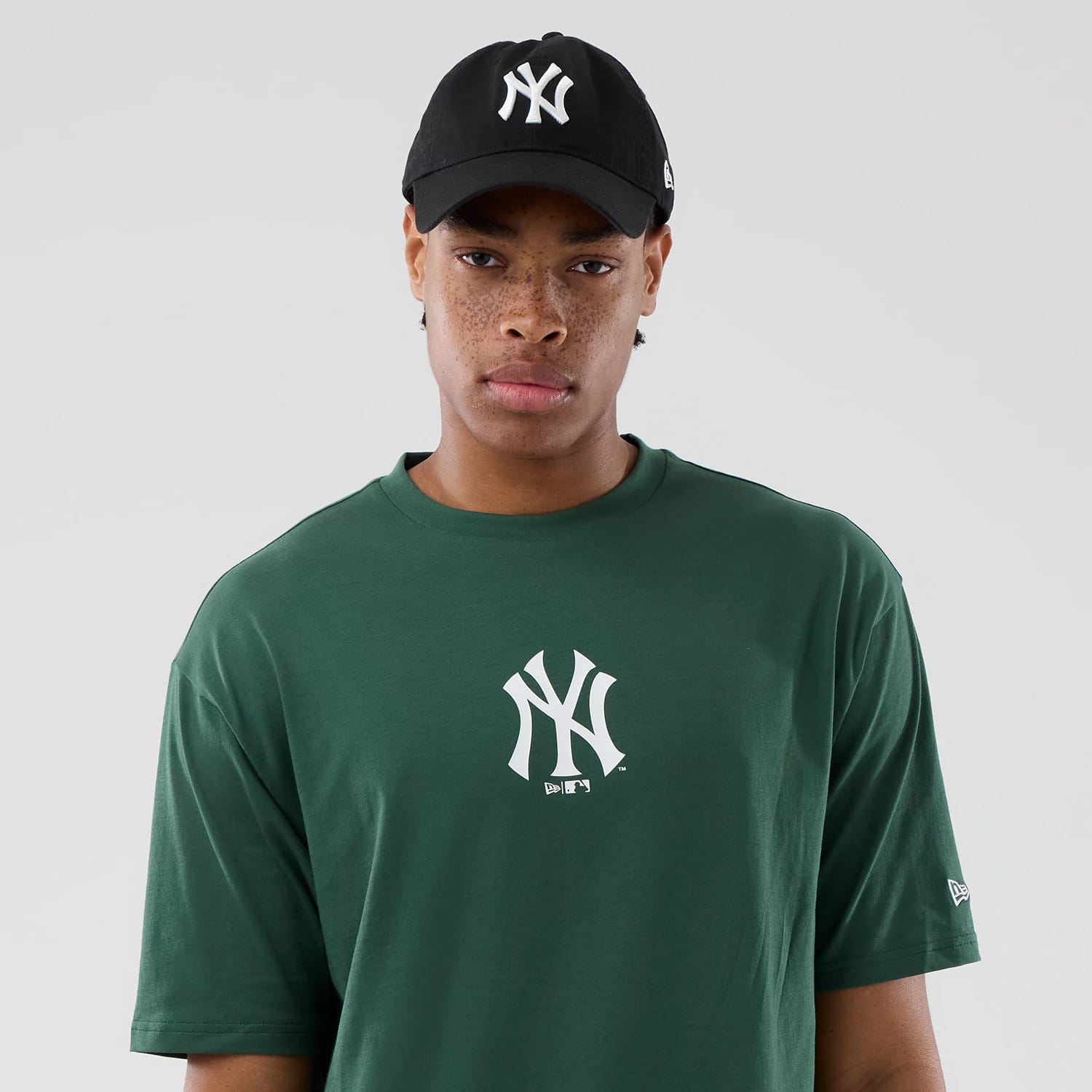 The model is wearing this MLB Food Graphic New York Yankees Oversized T-Shirt in dark green. 6