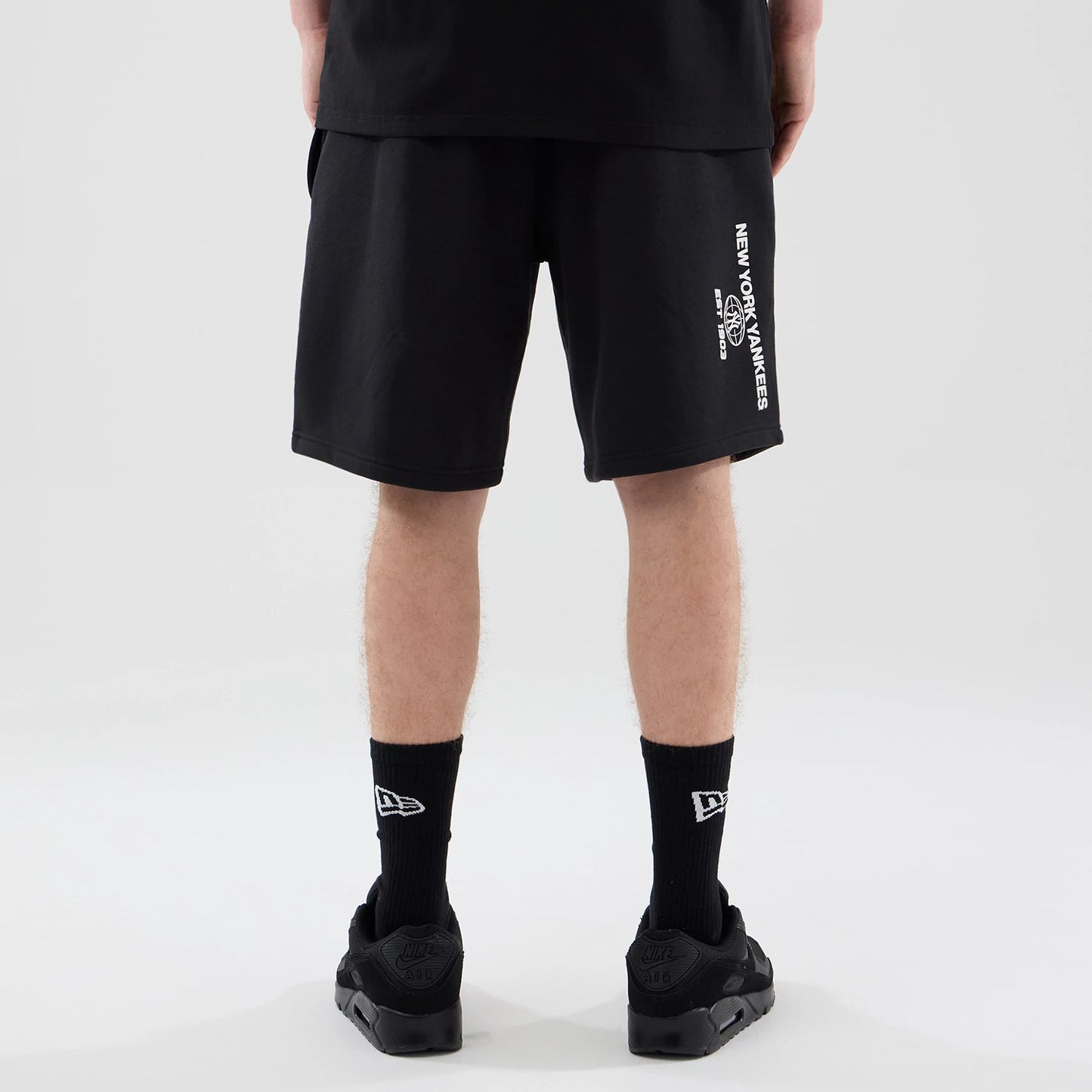 The model is wearing these MLB Logo Graphic New York Yankees Oversized Shorts in black. 2