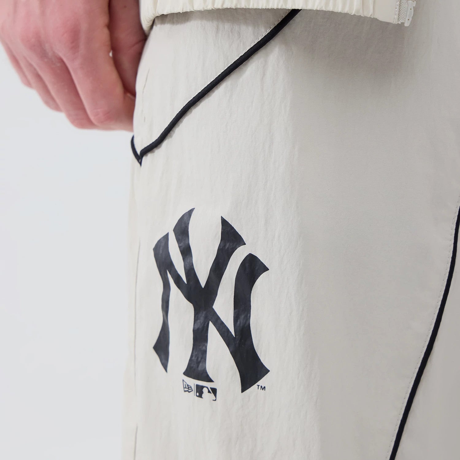 The model is wearing these MLB Piping Track New York Yankees Track Pants in cream. 4