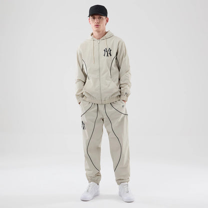 The model is wearing these MLB Piping Track New York Yankees Track Pants in cream. 8
