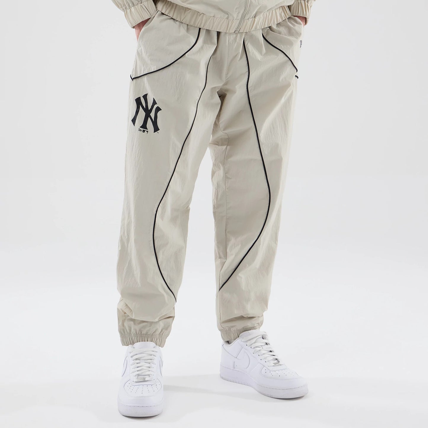 The model is wearing these MLB Piping Track New York Yankees Track Pants in cream. 1