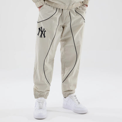 The model is wearing these MLB Piping Track New York Yankees Track Pants in cream. 1