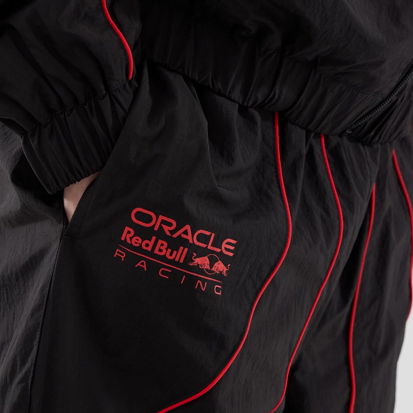 The model is wearing these Red Bull Racing Piping Track Pants in black. 5