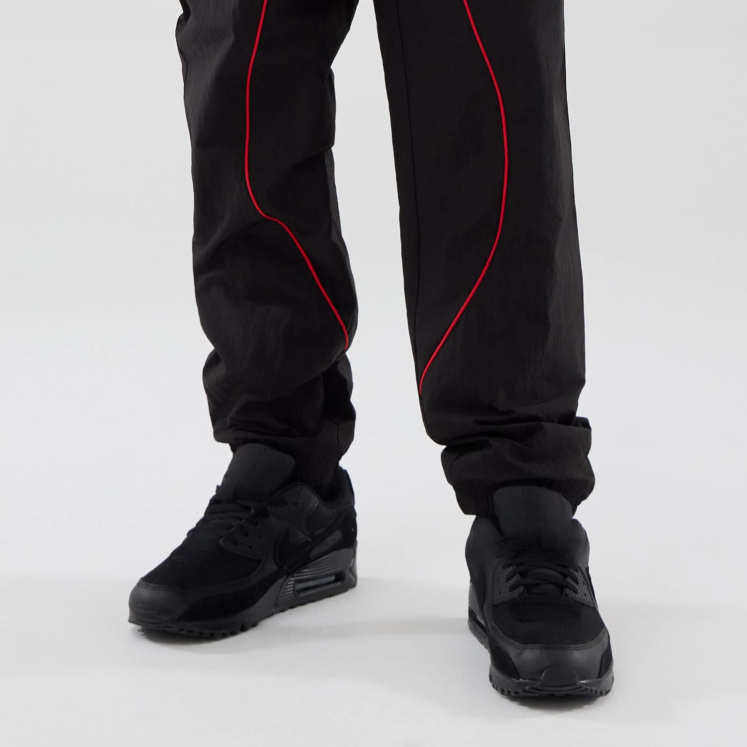 The model is wearing these Red Bull Racing Piping Track Pants in black. 7