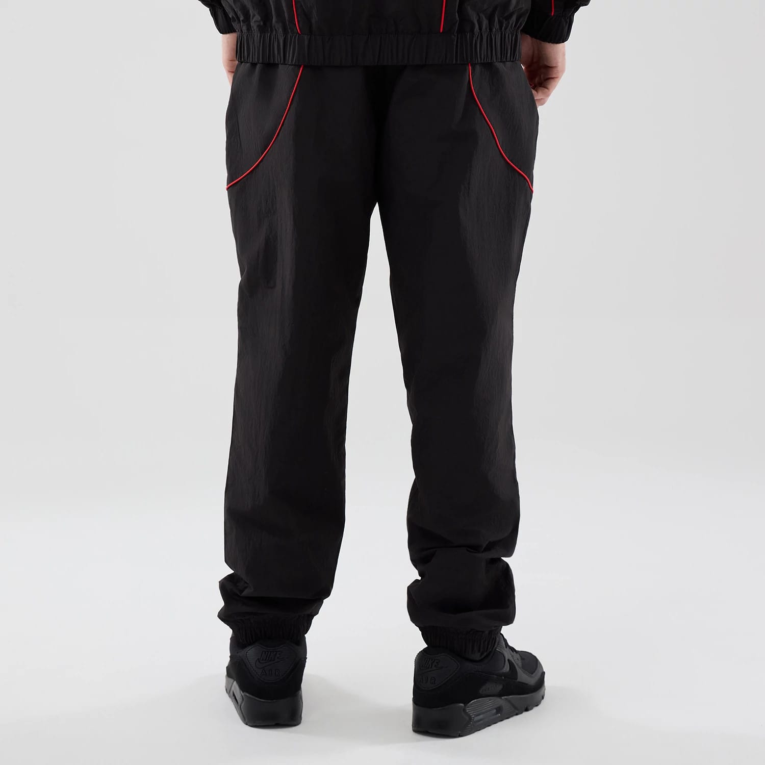The model is wearing these Red Bull Racing Piping Track Pants in black. 2
