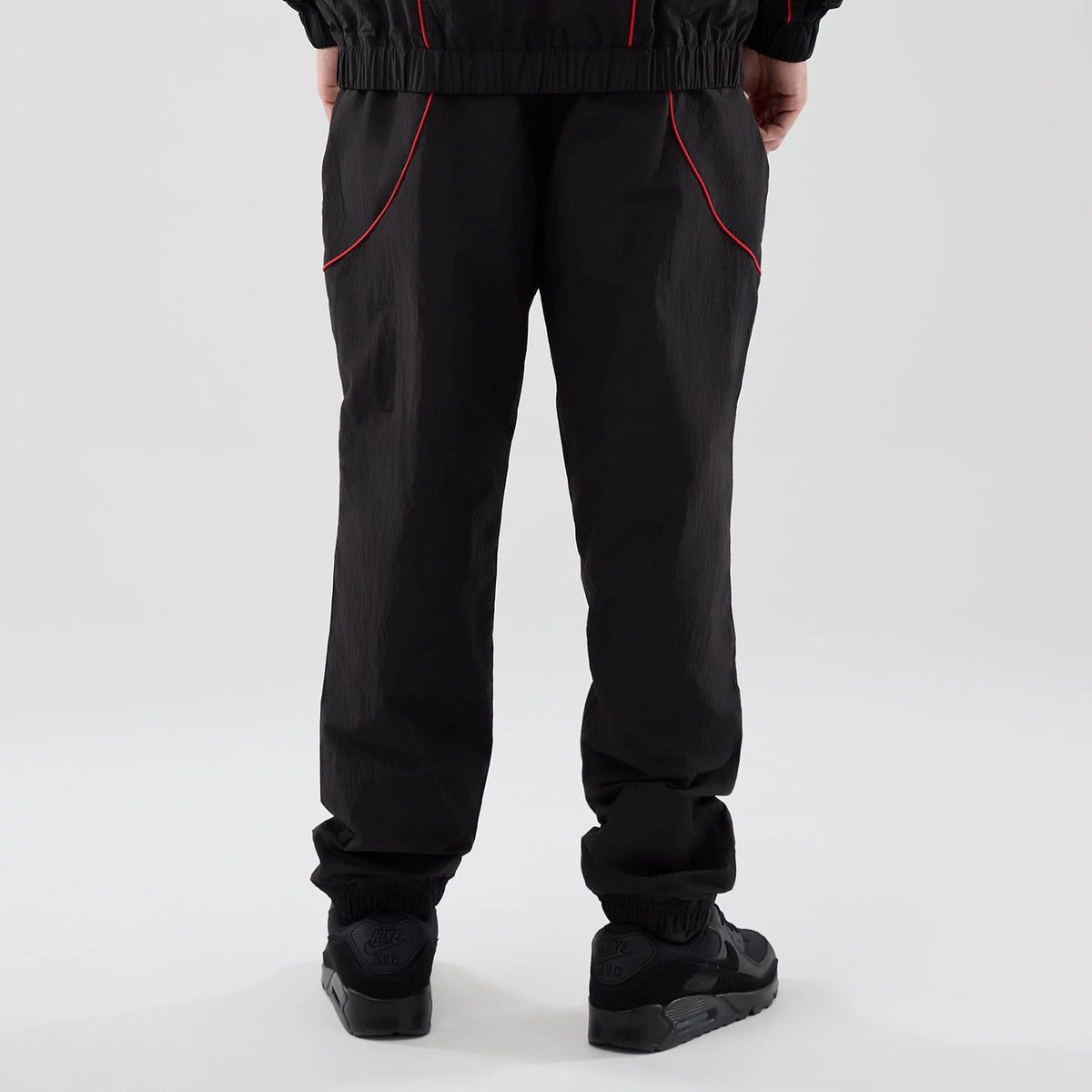 The model is wearing these Red Bull Racing Piping Track Pants in black. 2