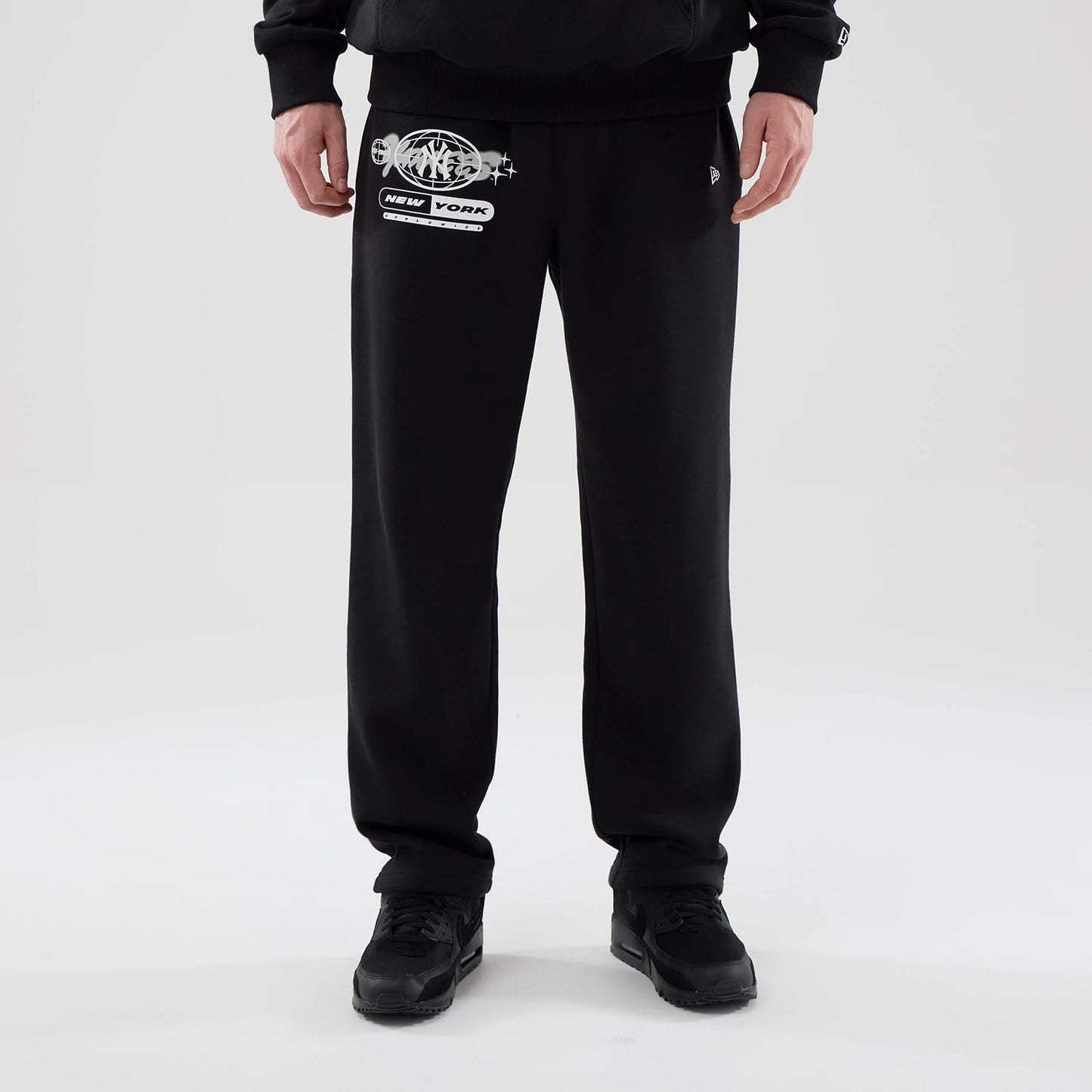 The model is wearing these MLB Logo Graphic New York Yankees Straight Leg Joggers in black. 1