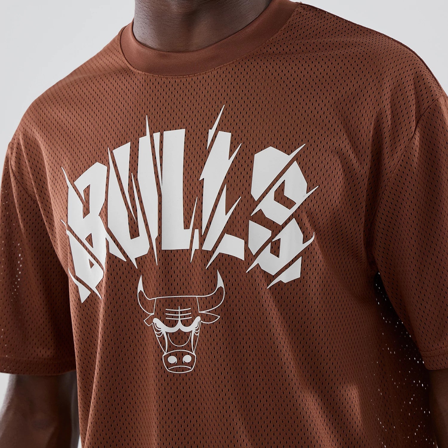 The model is wearing this NBA Core Plus Mesh Chicago Bulls Oversized T-Shirt in brown. 4