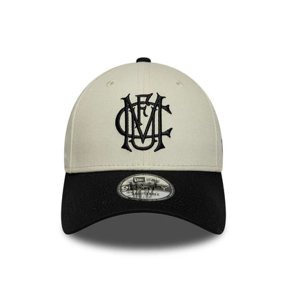 Manchester United FC Monogram Cream & Black New Era 9FORTY Adjustable Cap, front view showing a raised embroidered black monogram logo on the cream front panel, a contrasting black curved visor, and the 9FORTY size sticker on the visor.