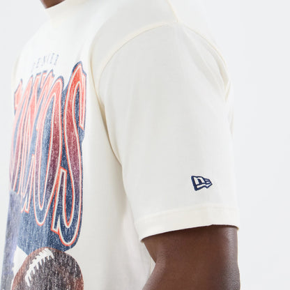 New Era Denver Broncos NFL Sport Classic Cream T-Shirt, three-quarter view showing the Broncos graphic across the chest in blue and orange, a football graphic below, and the embroidered New Era logo on the short sleeve, worn by a model.