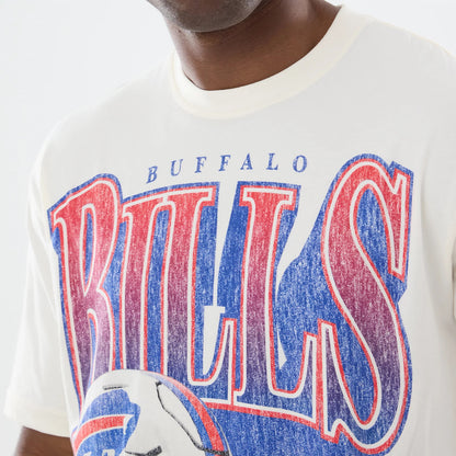 New Era Buffalo Bills NFL Sport Classic Cream T-Shirt, front view showing large distressed red and blue Bills lettering across the chest, a graphic football below, and Buffalo text above, worn by a model in a casual style.
