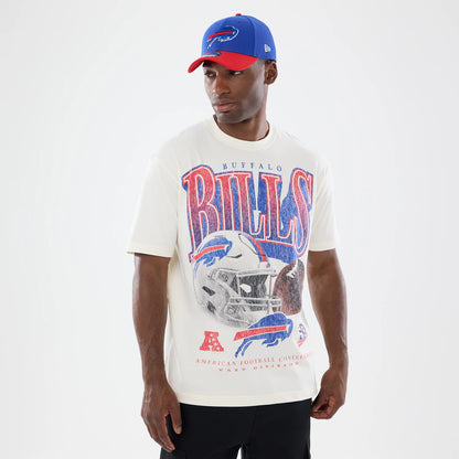 New Era Buffalo Bills NFL Sport Classic Cream T-Shirt, front view on-model featuring large vintage-style Bills lettering and a detailed football helmet graphic, with matching red and blue accents, styled with a New Era red and blue cap.