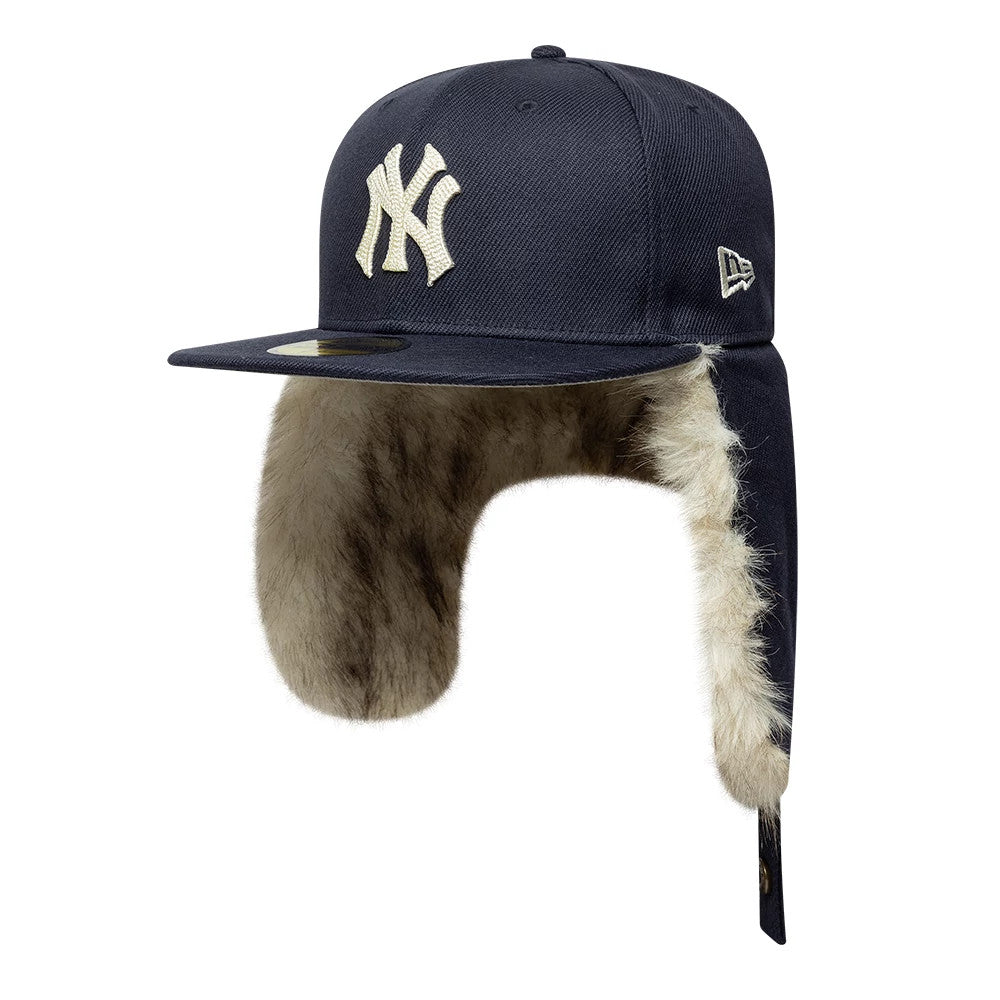 New York Yankees MLB Cotton Canvas Navy Dogear New Era 59FIFTY Fitted Cap, three-quarter view showing the raised white New York Yankees logo on the front panel, flat navy visor with gold 59FIFTY size sticker, and faux fur-lined ear flaps.