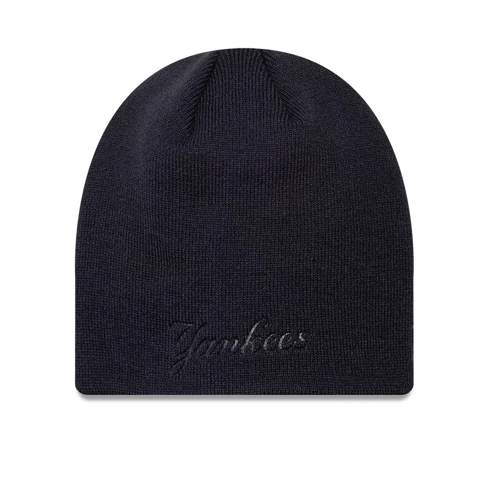 New Era New York Yankees MLB Script Navy Skull Knit Beanie Hat, front view showing raised embroidery of the Yankees script logo on the lower edge of the soft navy knit fabric, with a rounded crown shape and ribbed texture.