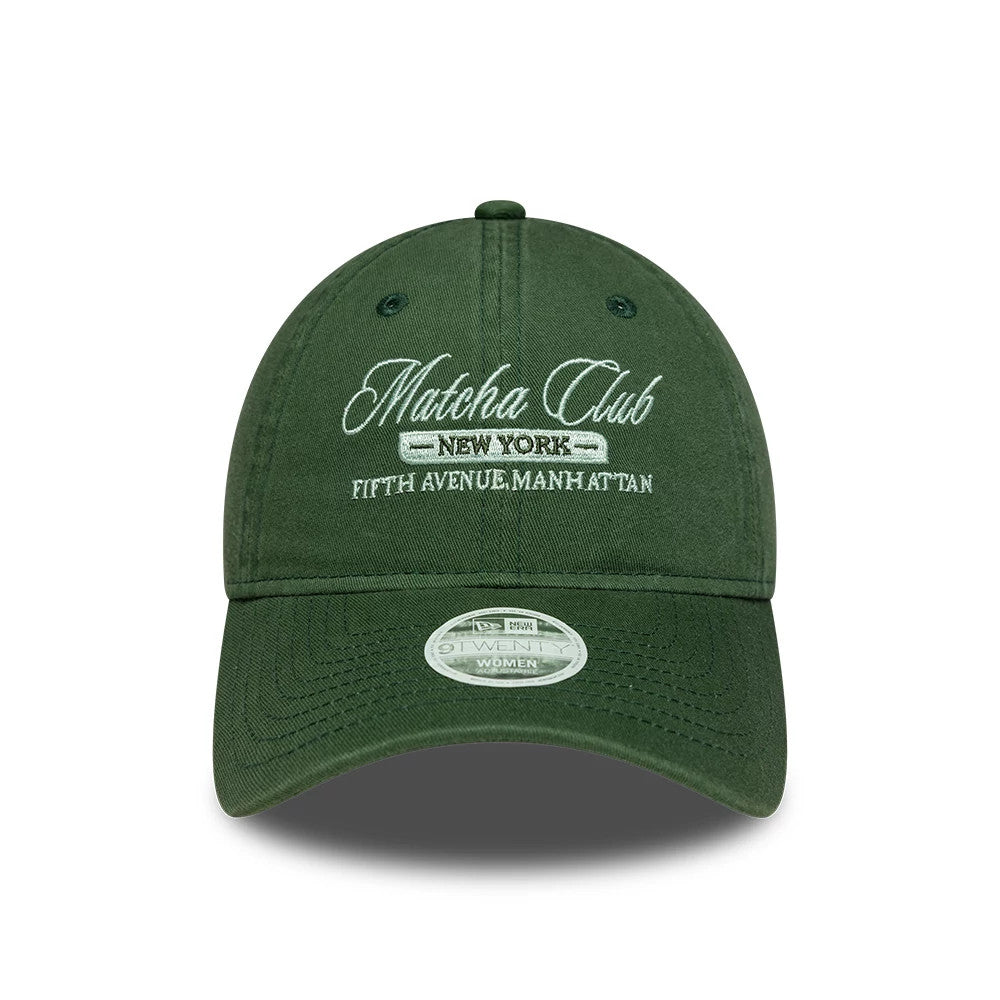 Womens New Era Café Slogan Dark Green 9TWENTY Adjustable Cap, front view showing white embroidered Matcha Club script logo and New York, Fifth Avenue, Manhattan underneath on the front panel, with a 9TWENTY size sticker on the curved visor.