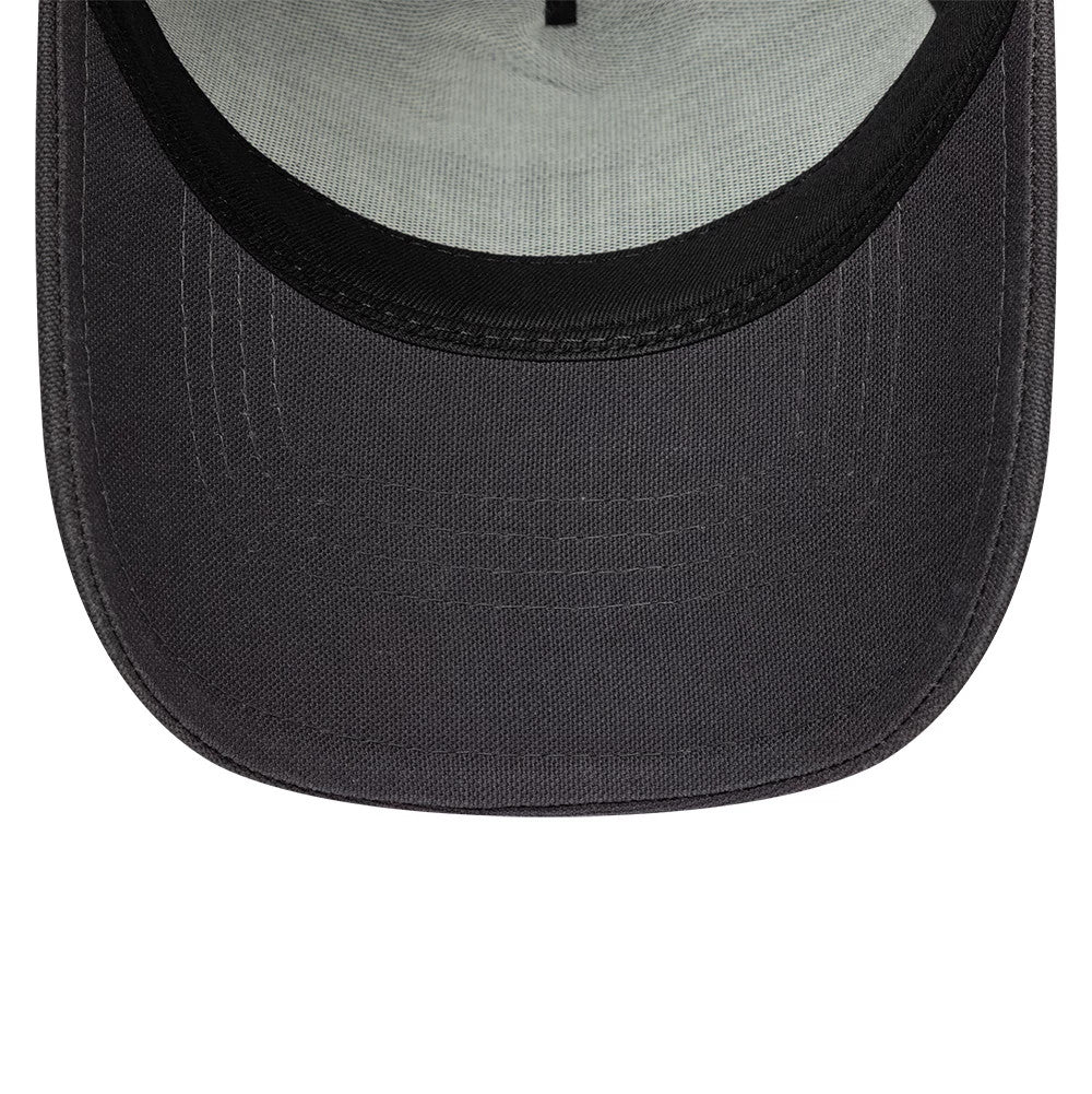 New Era Distressed Patch Charcoal New Era 9FORTY E-Frame Trucker Adjustable Cap, inside view showing a pale green undervisor with a black interior edge, black stitching, and curved visor on the hat.