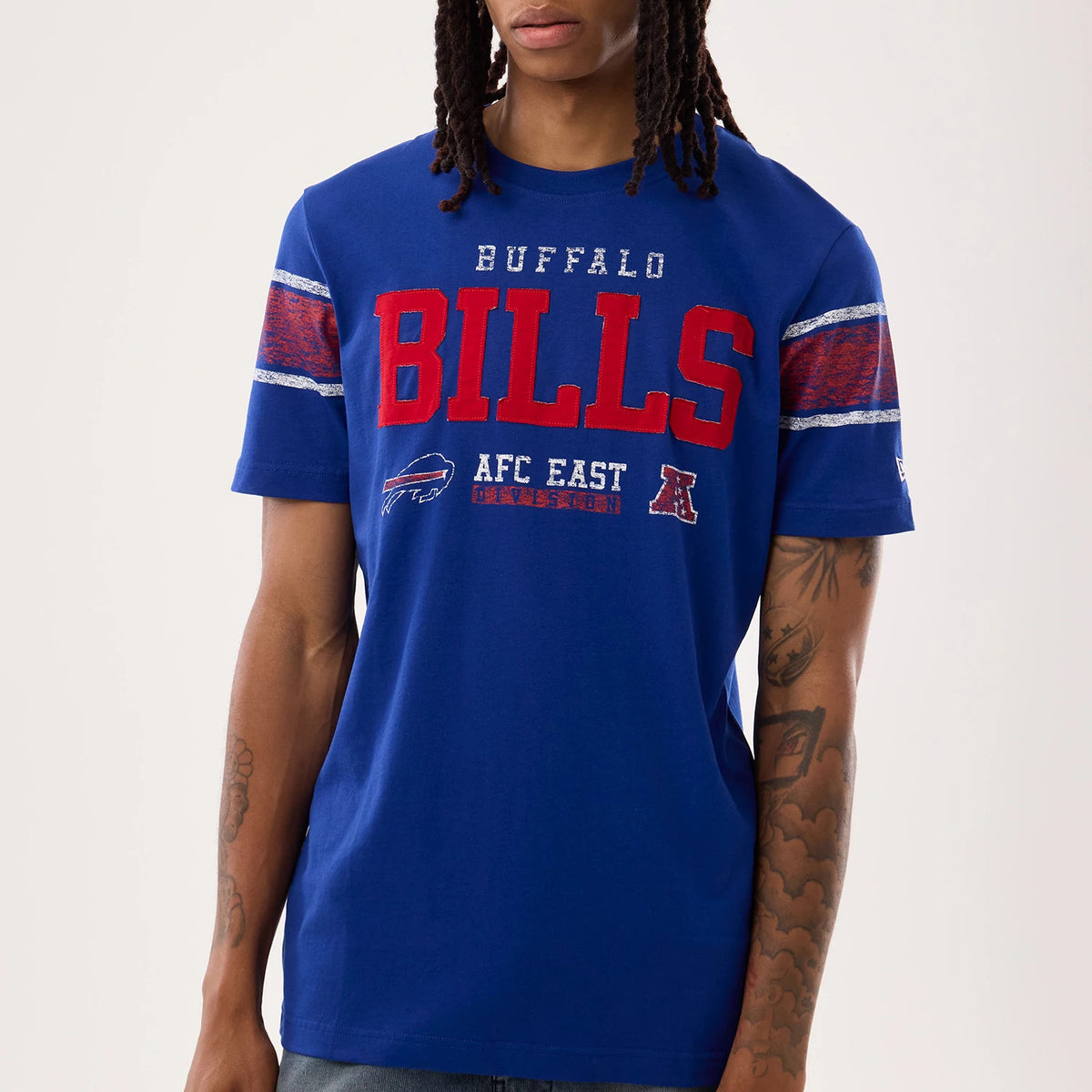 New Era Buffalo Bills NFL Sideline 2026 Blue T-Shirt, front view on-model showcasing red embroidered BILLS lettering across the chest, BUFFALO text above, decorative stripes on the sleeves and a small New Era logo on the left sleeve.