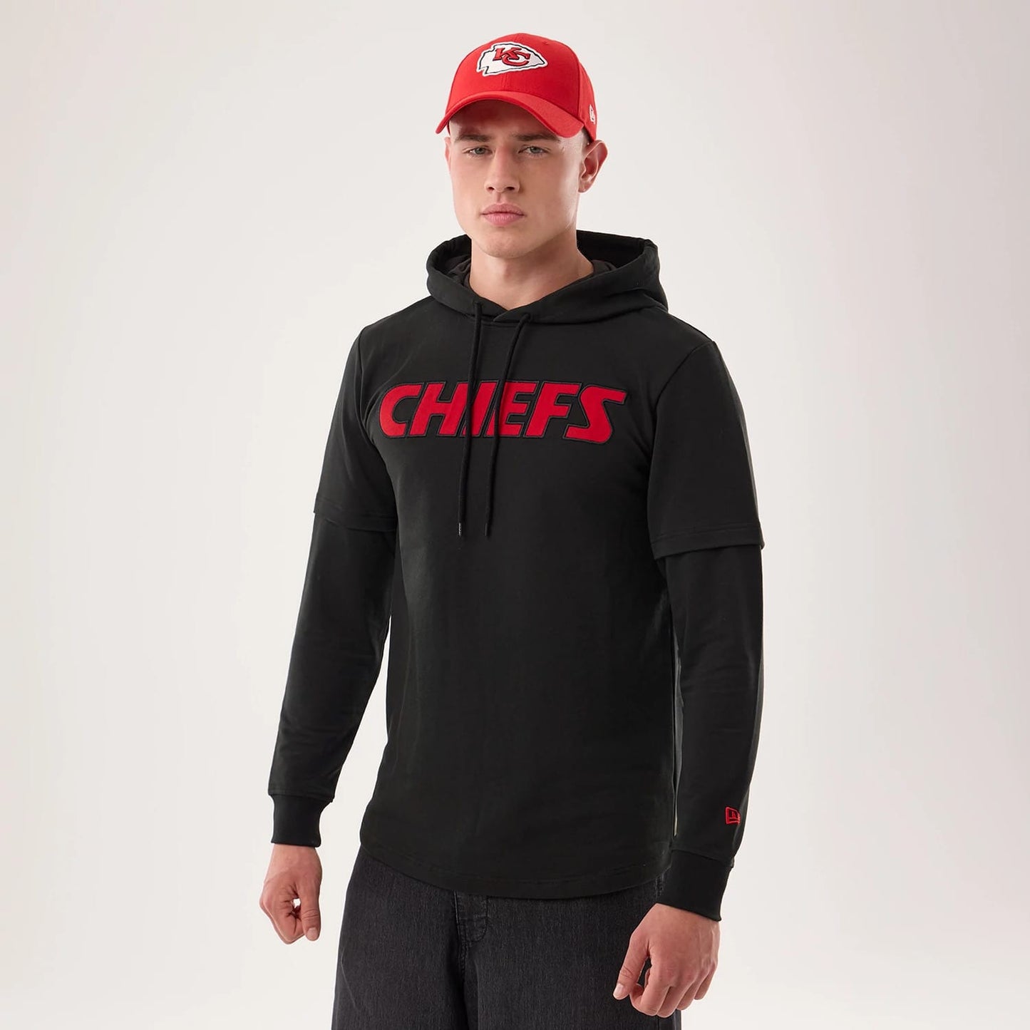 The model is wearing this NFL Sideline 2026 Kansas City Chiefs Double Sleeve Hoodie in black. 1