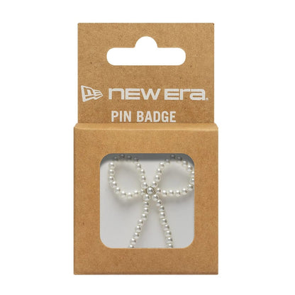 Pictured is this New Era Faux Pearl Bow Pin Badge in White. 3