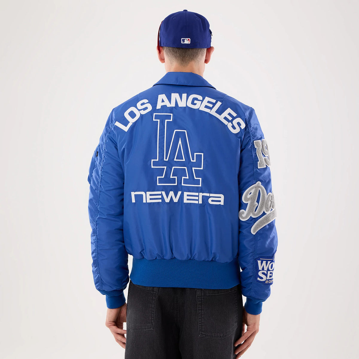 The model is wearing this MLB X Alpha LA Dodgers Jacket in Blue. 2