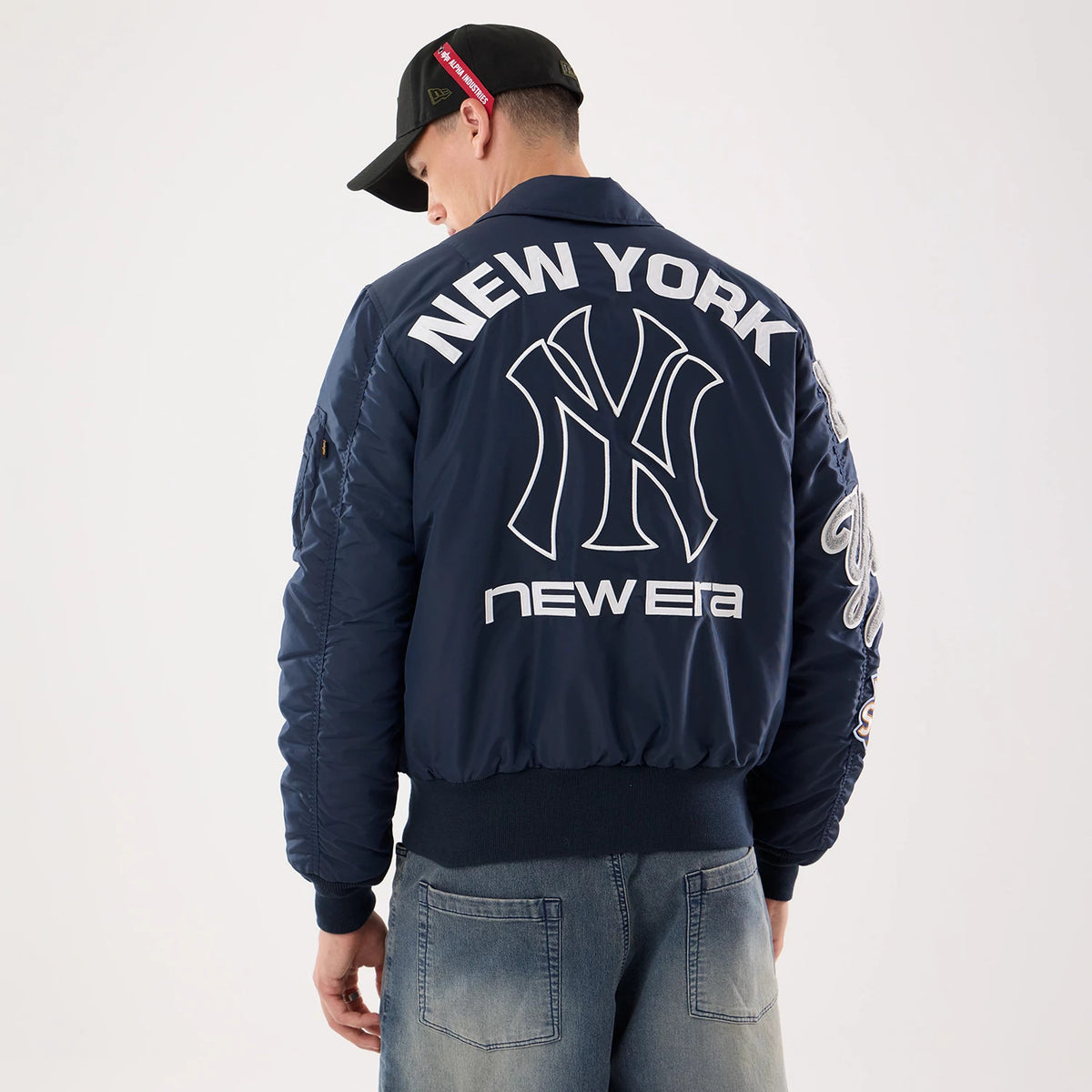 The model is wearing this MLB X Alpha New York Yankees Jacket in navy. 2