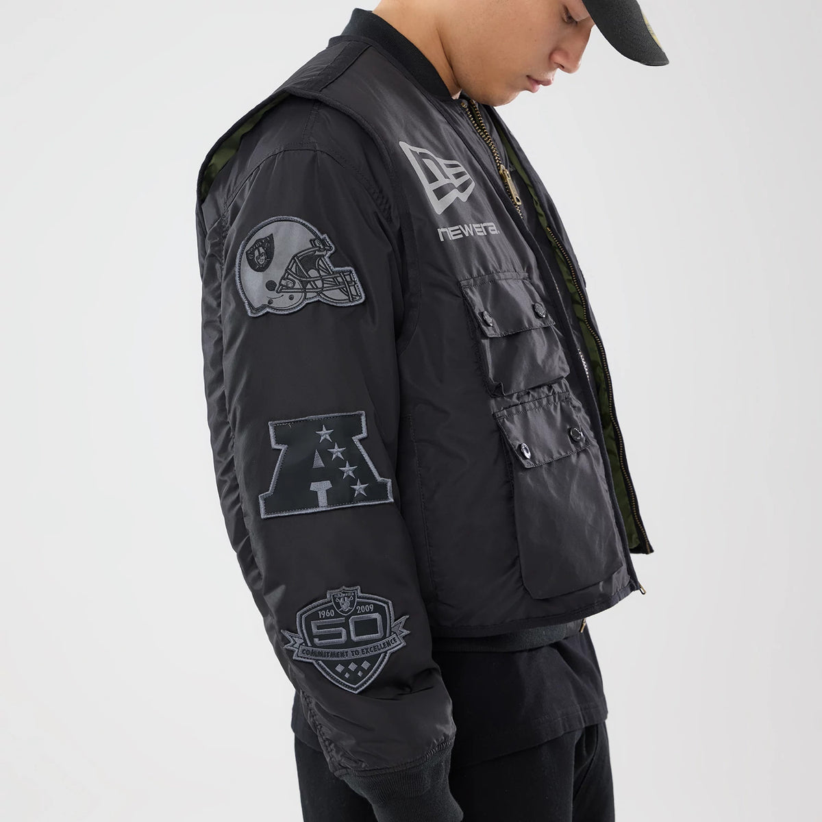 The model is wearing this NFL X Alpha Las Vegas Raiders Bomber Jacket & Tactical Vest in black. 4