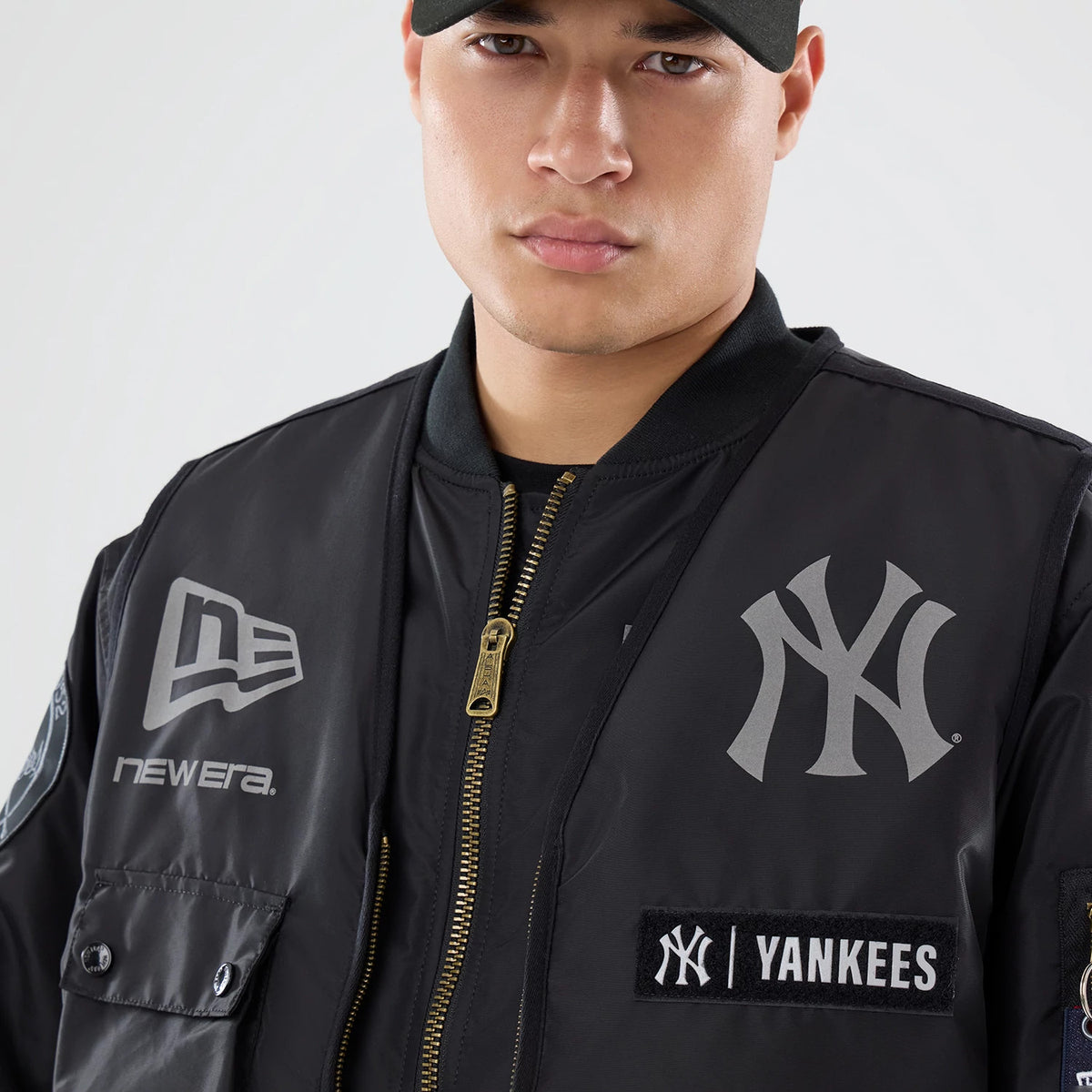 The model is wearing this MLB X Alpha New York Yankees Bomber Jacket & Tactical Vest in black. 3