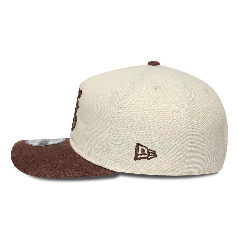 New Era Suede Visor Cream 9FIFTY A-Frame Adjustable Cap, side view showing a brown embroidered New Era flag logo on the left side, a structured cream crown with matching top button, and a brown suede flat visor with a 9FIFTY size sticker.