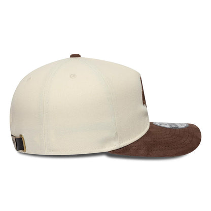 New Era Suede Visor Cream 9FIFTY A-Frame Adjustable Cap, side view showing the New Era flag logo on the left side of the structured cream crown, with a contrasting brown suede curved visor and a 9FIFTY size sticker.