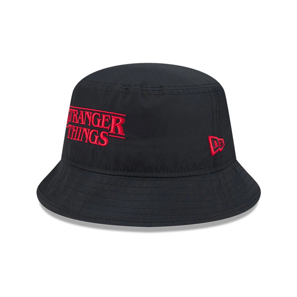 Netflix Stranger Things Black New Era Bucket Hat, three-quarter view showing the red embroidered Stranger Things logo on the front, a red New Era flag logo on the left side, and a full visor with stitched detailing.