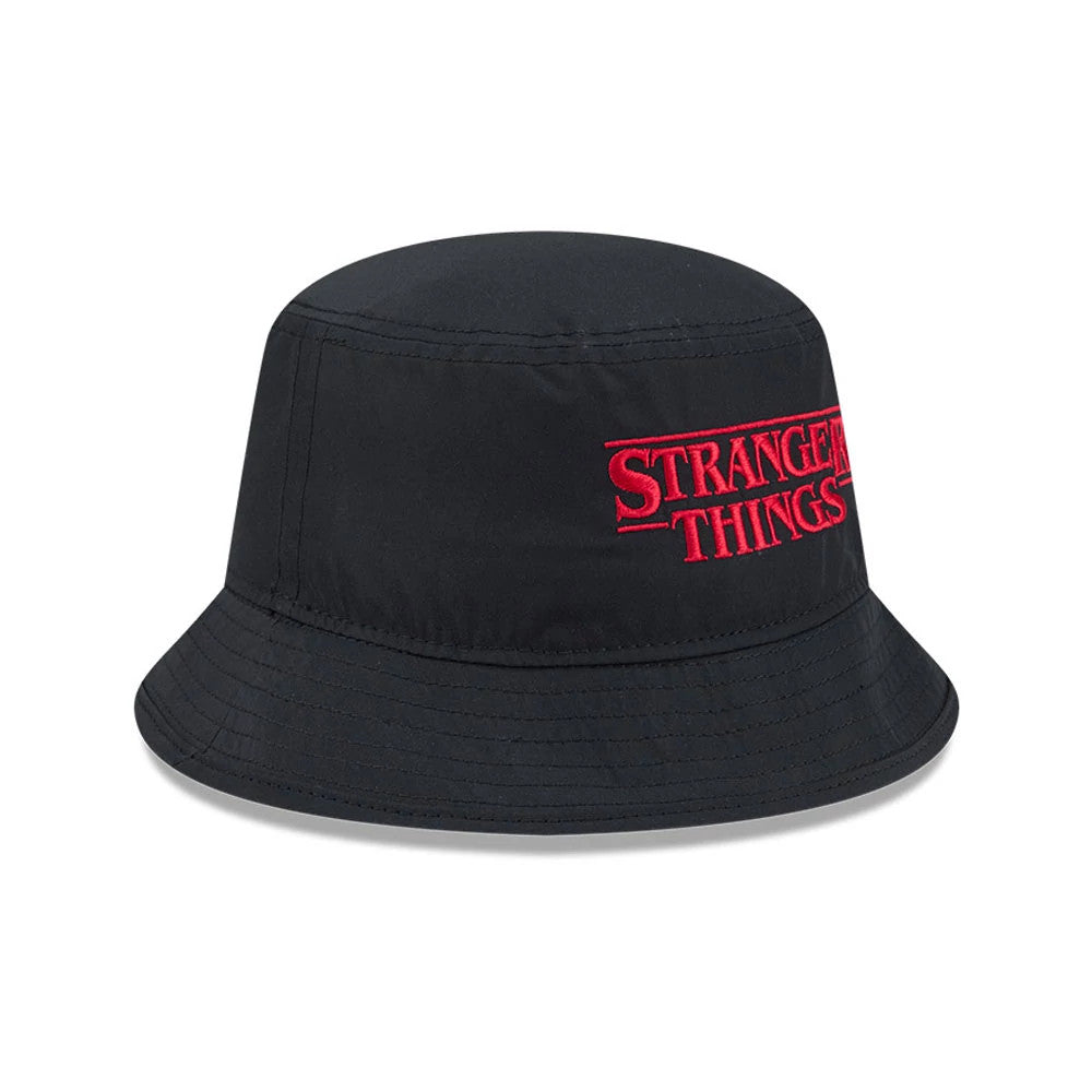 New Era Netflix Stranger Things Black Bucket Hat, front view showing the bright red embroidered Stranger Things logo on the structured black crown, with even stitching along the visor and a finish on the fabric panels.