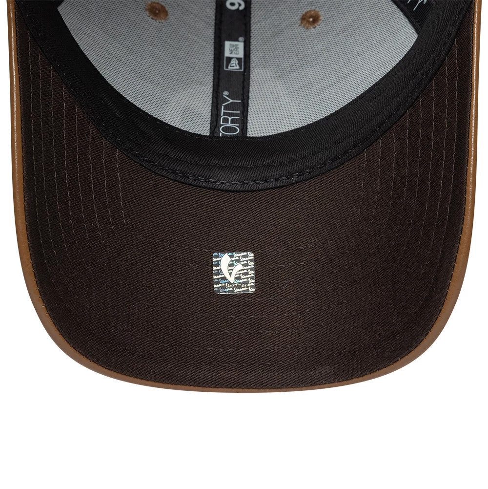 Vespa Crinkle PU Dark Brown New Era 9FORTY Adjustable Cap, inside view showing the black undervisor with a size sticker, grey taping with a 9FORTY logo, and a contrasting brown sweatband along the edge, highlighting detailed stitching.