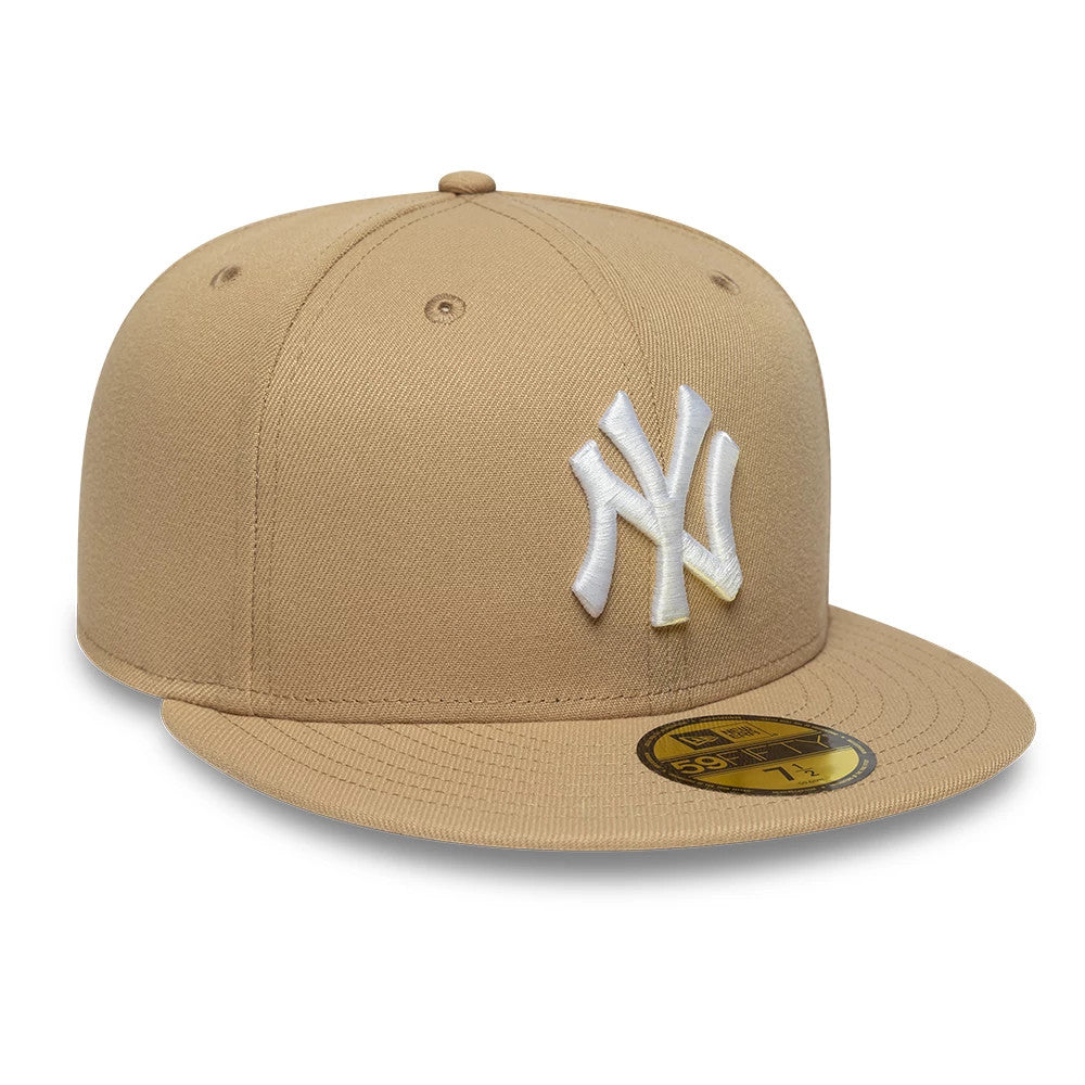 New York Yankees MLB League Essential Light Beige New Era 59FIFTY Fitted Cap, three-quarter view showing the raised white embroidered NY logo on the front panel, a matching light beige flat visor, and a gold 59FIFTY size sticker.