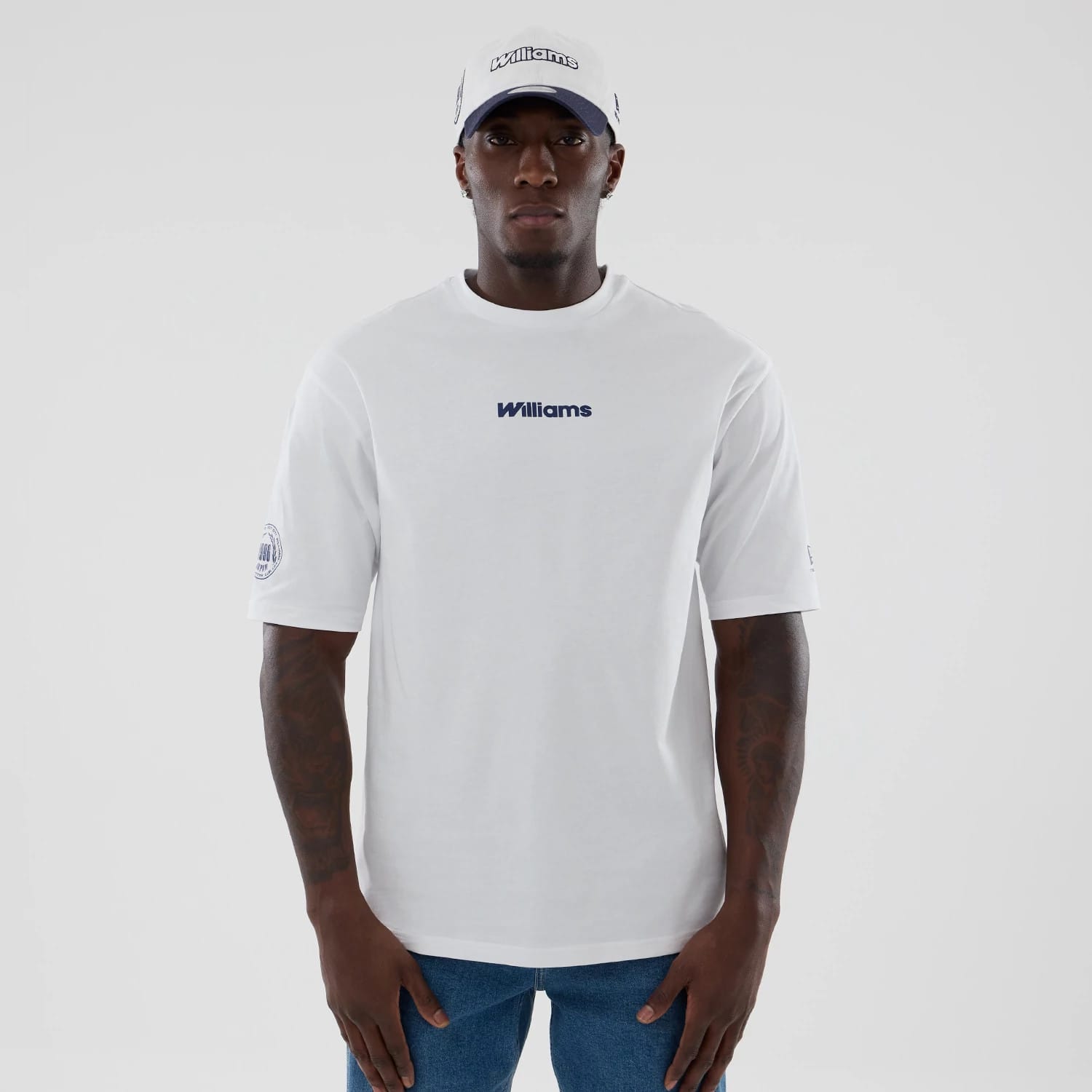 The model is wearing this Atlassian Williams F1 Team Japan 1996 Script World Champions Oversized T-Shirt in white. 1