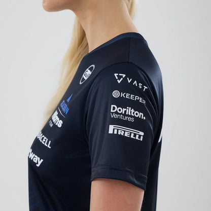 New Era Williams Womens Navy Tech T-shirt, side view on a model displaying multiple white printed sponsor logos, including Pirelli on the sleeve, with a close-fitting navy neckline and a cuff edge on the short sleeve.